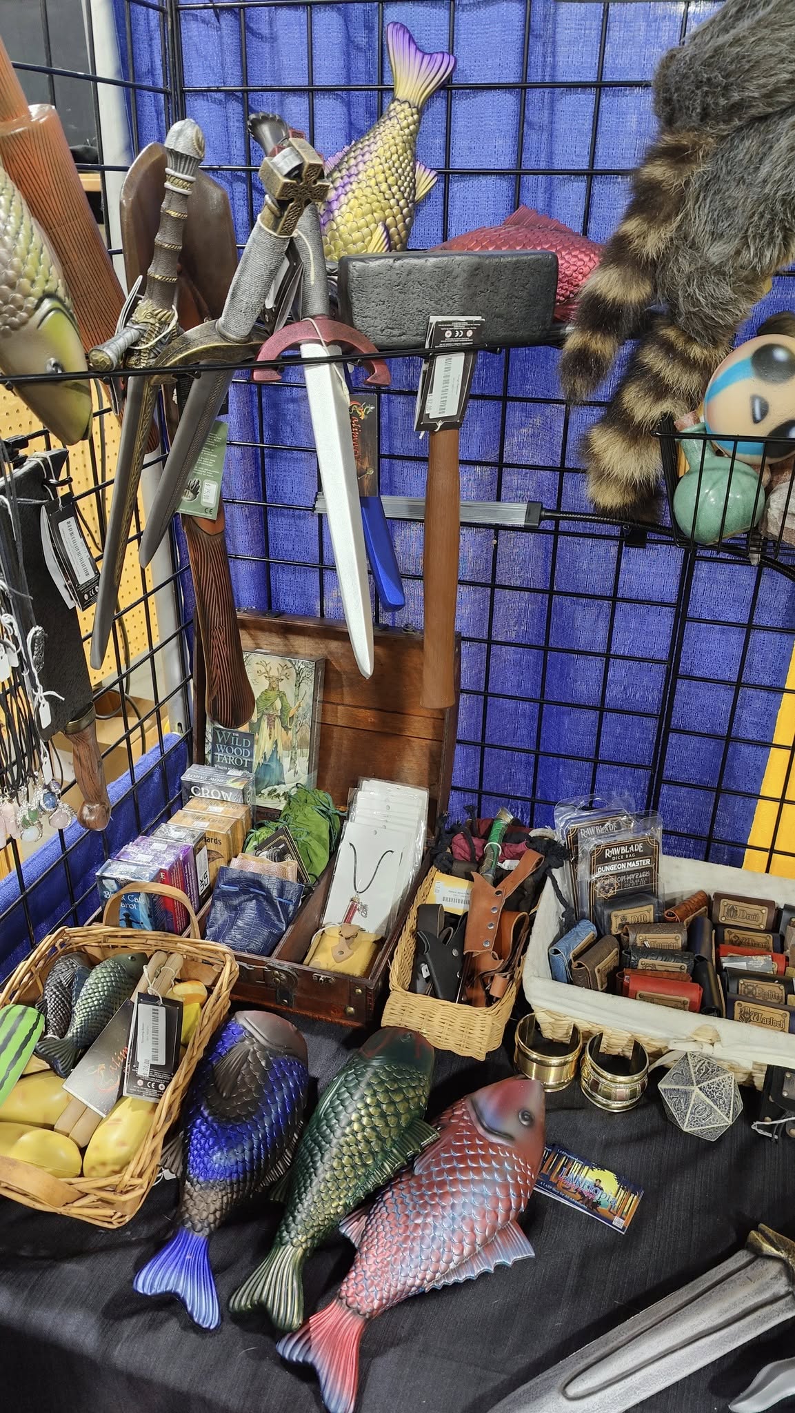 motor city comicon larptopia booth, table with tarot, runes, foam fish, dice sets, daggers, fur hats, foam potion throables, foam rock throwables, necklaces, foam food throwables